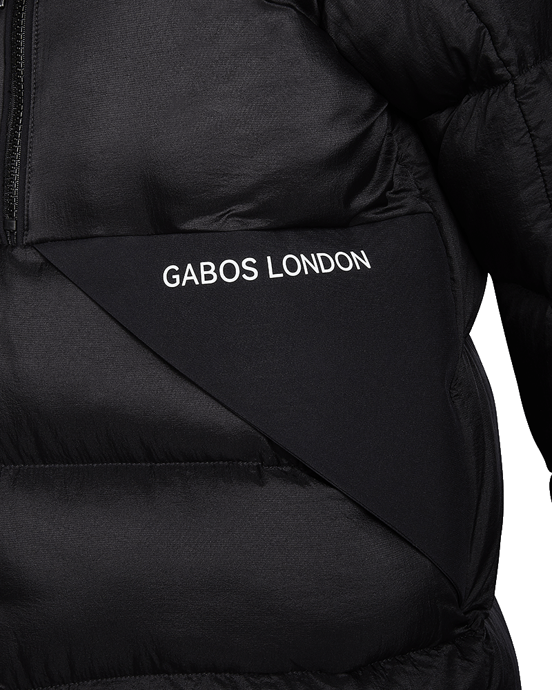 Close-up of a black puffer jacket with a diagonal panel featuring the white text 'GABOS LONDON'.