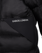 Close-up of a black puffer jacket with a diagonal panel featuring the white text 'GABOS LONDON'.