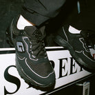 Model wearing GABOS LONDON G900 trainers styled with a woven windbreaker tracksuit
