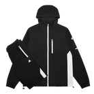 A black hooded jacket and matching black pants laid out on a white background. The jacket has a front zipper, a vertical chest zipper, a vertical white stripe on the side, and small white logo details.