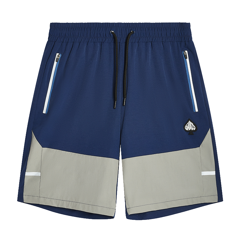 A pair of men's colorblock shorts in navy blue, light gray, and white, featuring an elastic waistband, black drawstring, zippered side pockets, and a small embroidered logo patch on the left thigh.