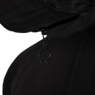 Close-up of a black hooded garment with a black zipper pull shaped like a spade, shown against a white background.