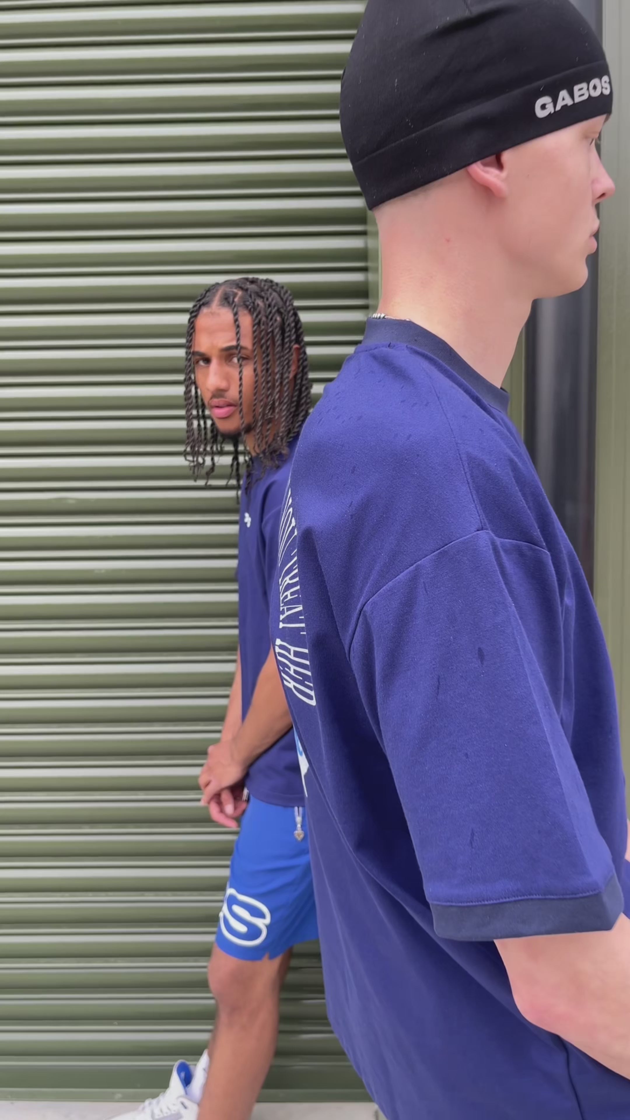 video of blue lifes a bitch t shirt by gabos london being worn by 2 models along with blue og gabos shorts 