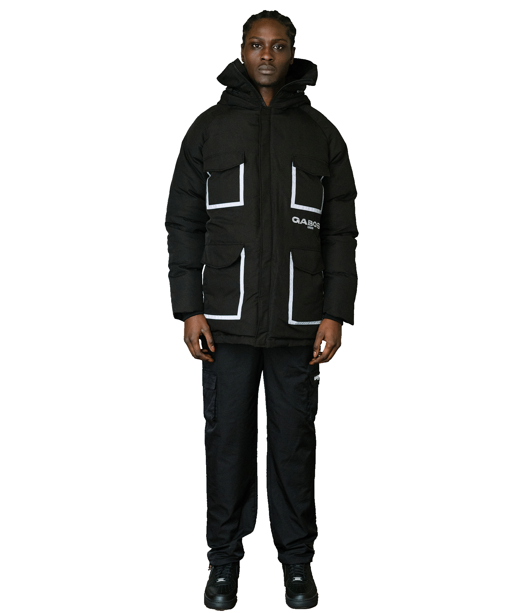A model wearing a black puffer jacket with white contrast stitching and pocket details, paired with black cargo pants and black shoes, set against a plain white background.